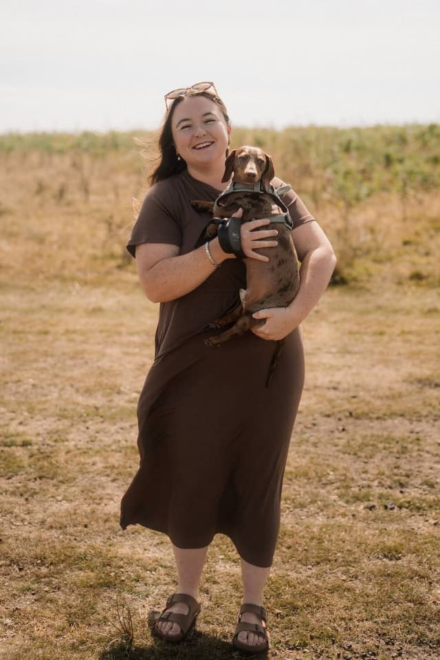 Beth holding her dachshund outdoors